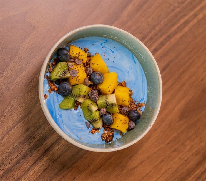 Blue spirulina smoothie bowl topped with kiwi, mango and granola