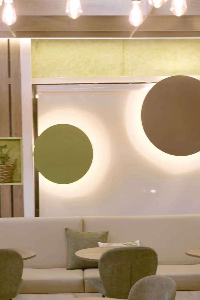 Pioppi's dining room with cream banquettes and olive-green chairs