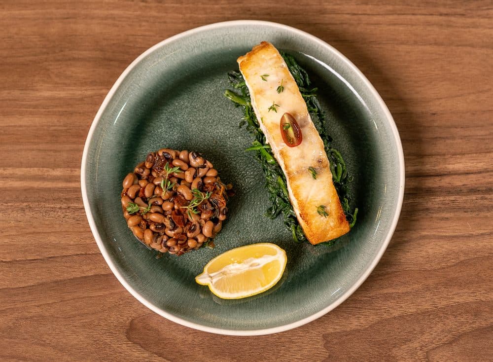 Poisson Grillé — grilled fish fillet with spinach, bean ragout and a lemon wedge